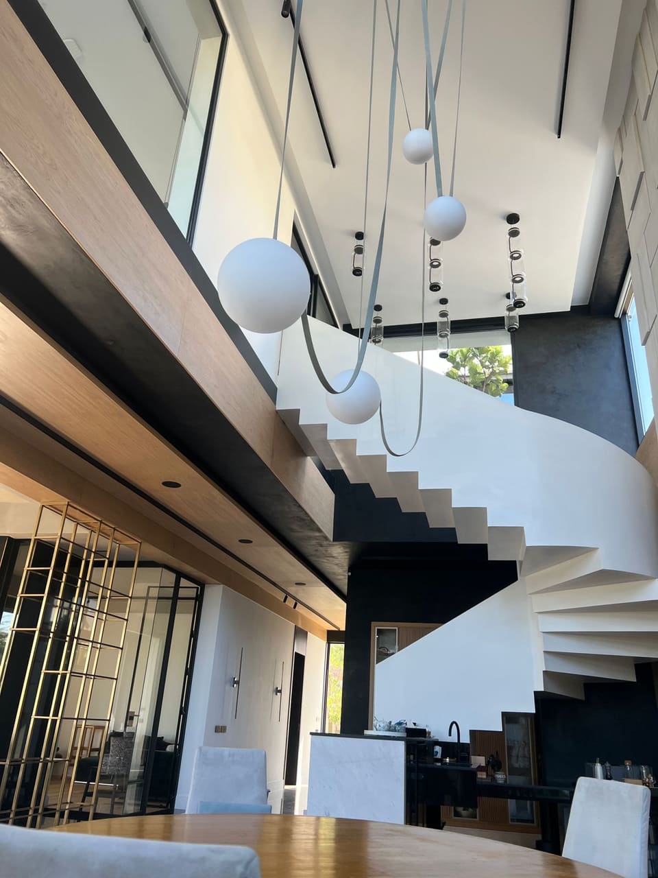 White spiral staircase and living room of a repainted villa