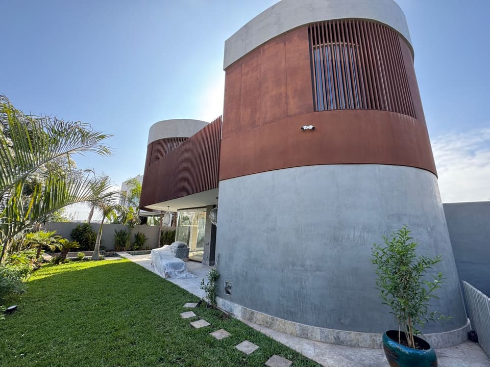 Contemporary villa with oxidised-metal finish seen from the garden