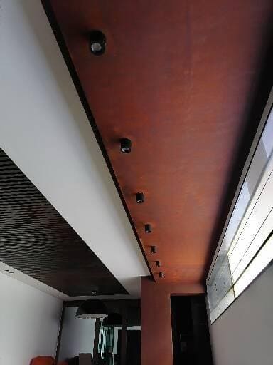 Ceiling with oxidised-metal effect finish and spotlights